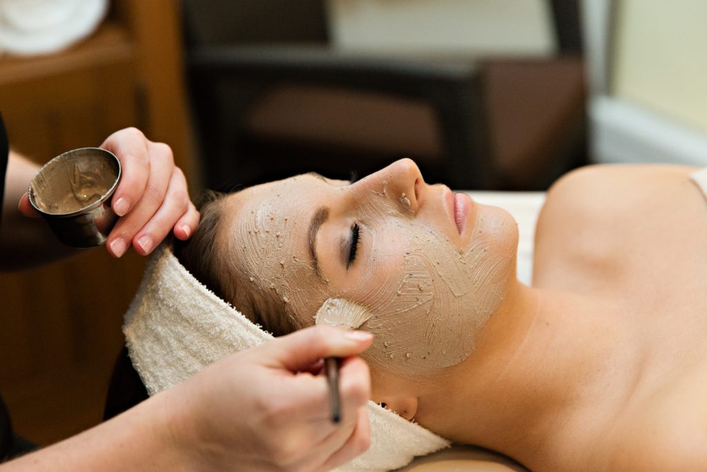 a woman getting a face mask treatment during a spa visit